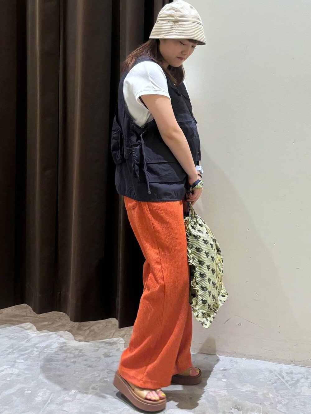 イエロー系のサンダル、ベージュ系のトートバッグ、ホワイト系のTシャツ/カットソーを着用したレディースの夏コーディネートの6枚目の写真