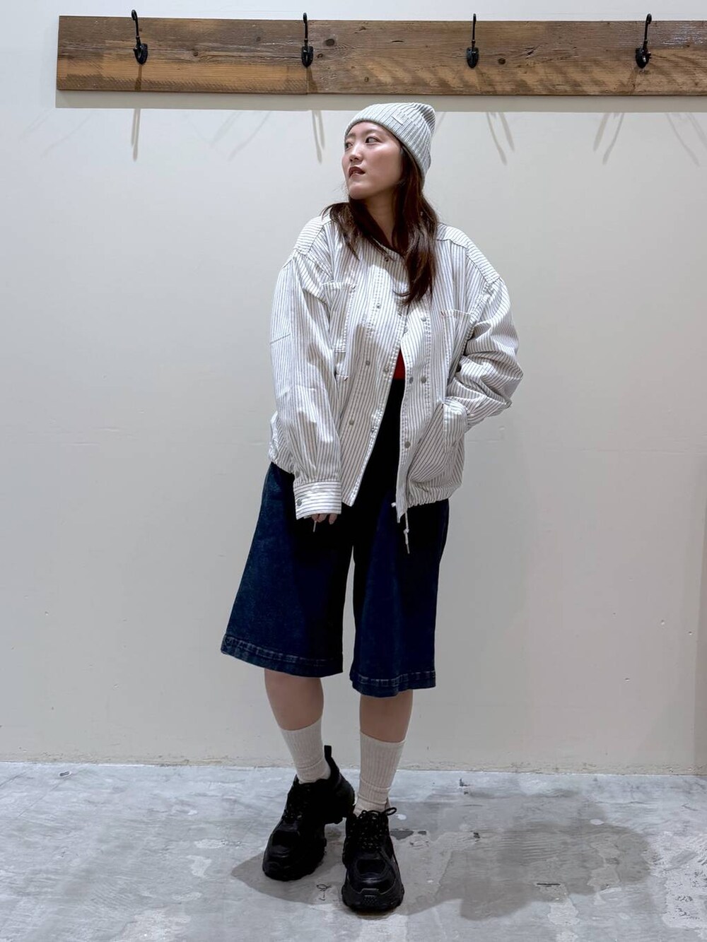 ブラック系のスニーカー、ベージュ系のカバーオール、レッド系のTシャツ/カットソーを着用したレディースの春コーディネートの5枚目の写真