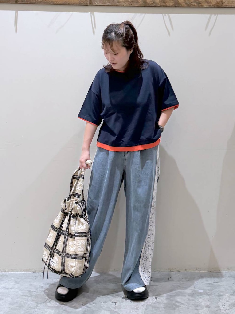 その他のトートバッグ、ブラック系のサンダル、ブルー系のTシャツ/カットソーを着用したレディースの夏コーディネートの2枚目の写真