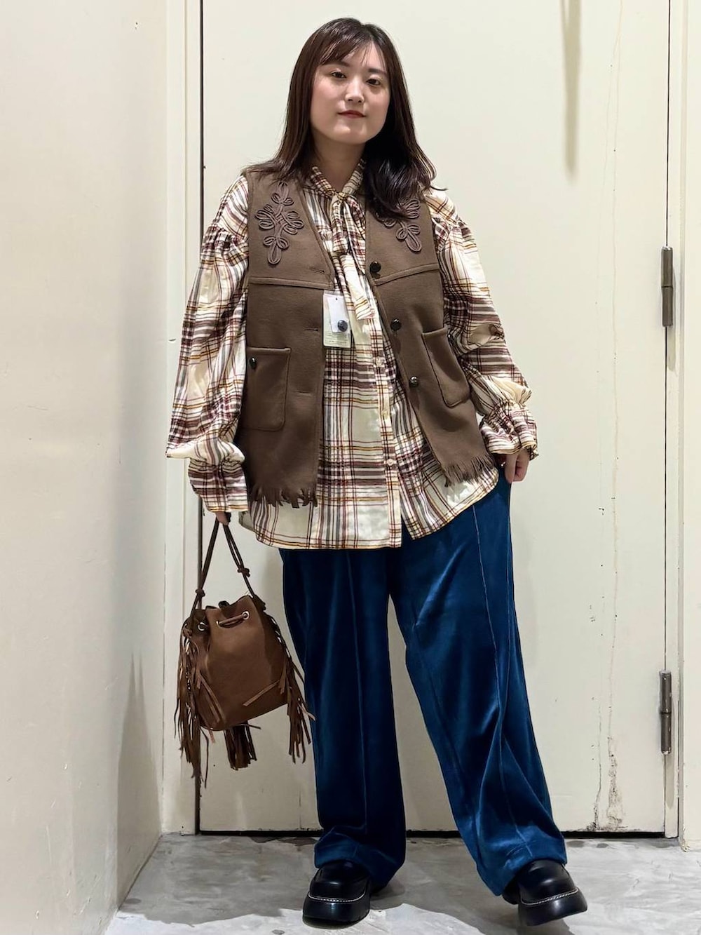 ブルー系のその他パンツ、ベージュ系のシャツ/ブラウス、イエロー系のベストを着用したレディースの秋コーディネートの3枚目の写真