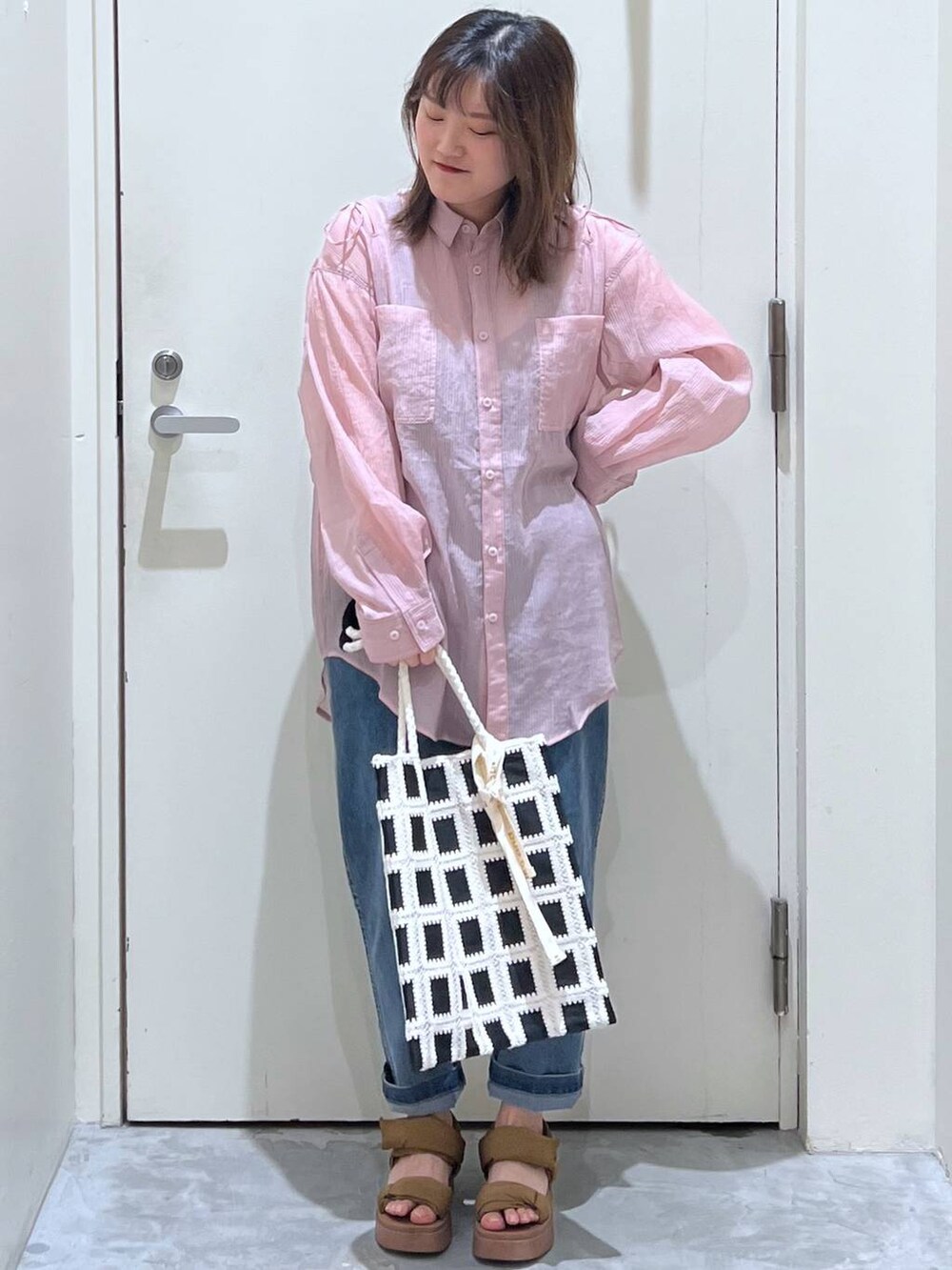 イエロー系のサンダル、ブラック系のトートバッグ、ブルー系のその他パンツを着用したレディースの春コーディネートの4枚目の写真