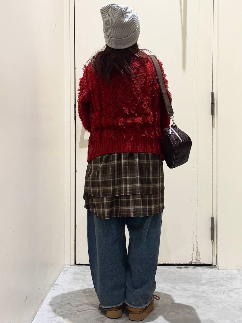 イエロー系のモカシン/デッキシューズ、ブルー系のデニムパンツ、レッド系のニット/セーターを着用したレディースの冬コーディネートの6枚目の写真