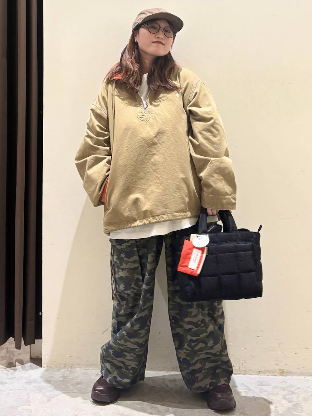 ブラック系のトートバッグ、ブラウン系のスニーカー、ベージュ系のパーカーを着用したレディースの春コーディネートの5枚目の写真