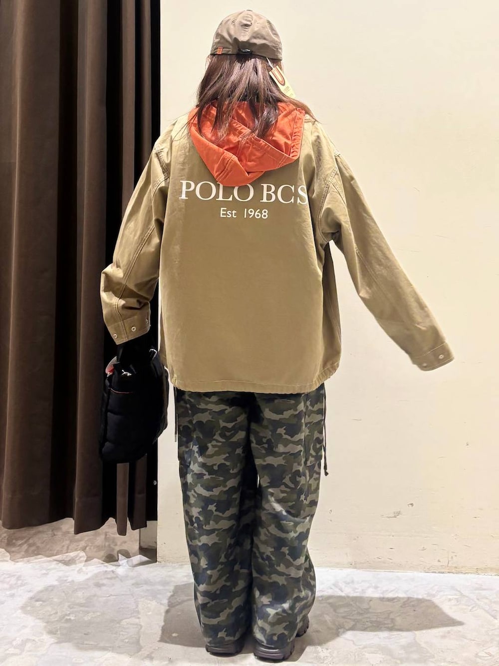 ブラック系のトートバッグ、ブラウン系のスニーカー、ベージュ系のパーカーを着用したレディースの春コーディネートの7枚目の写真