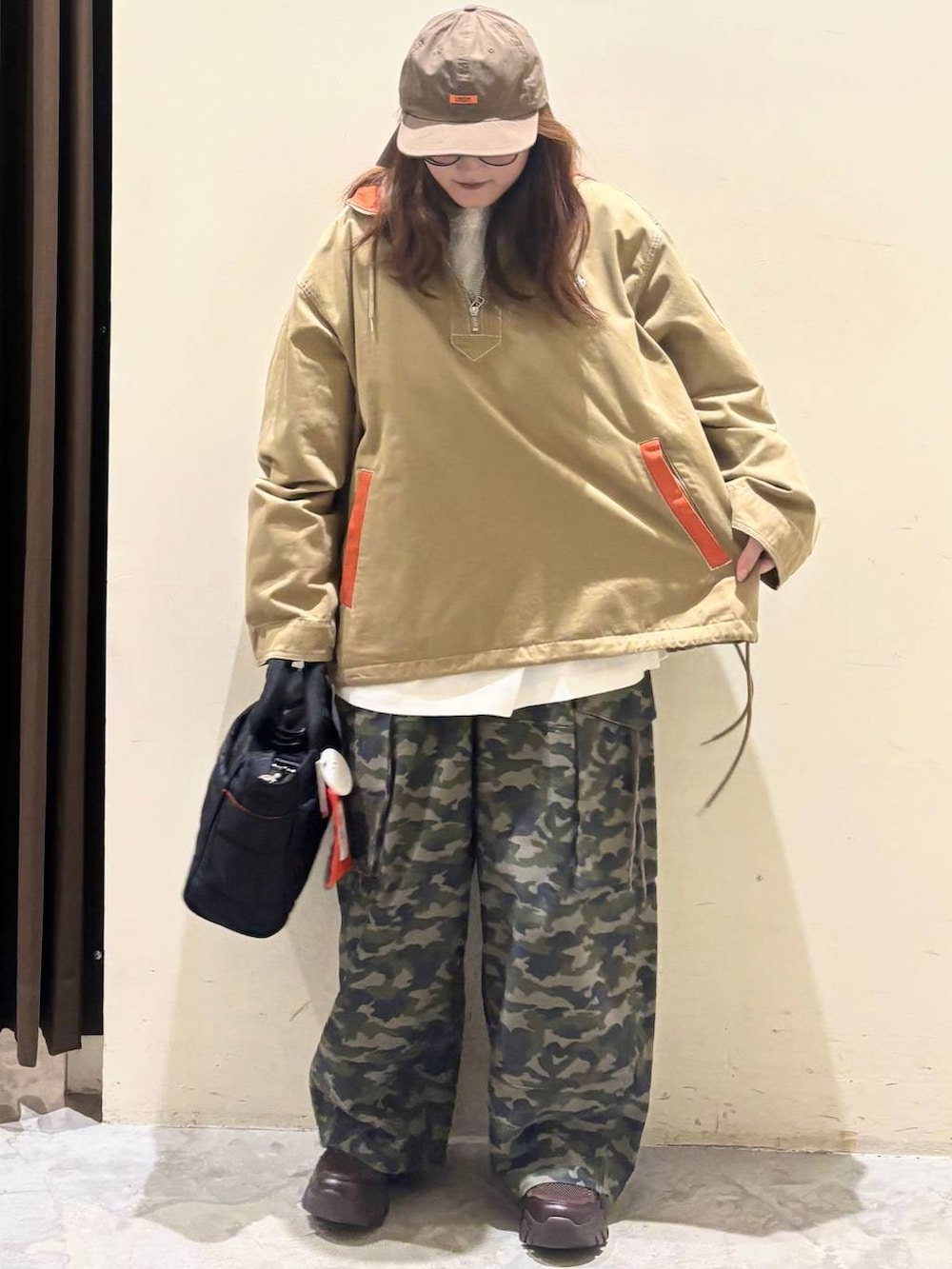 ブラック系のトートバッグ、ブラウン系のスニーカー、ベージュ系のパーカーを着用したレディースの春コーディネートの2枚目の写真