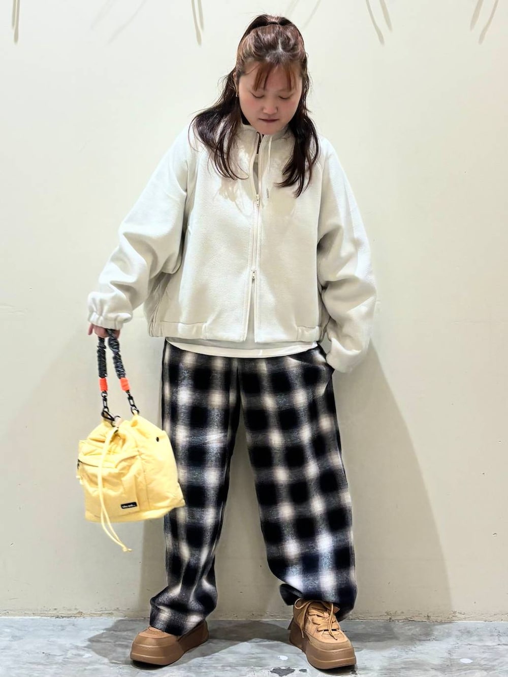 ブラウン系のスニーカー、イエロー系のショルダーバッグを着用したレディースの冬コーディネートの4枚目の写真