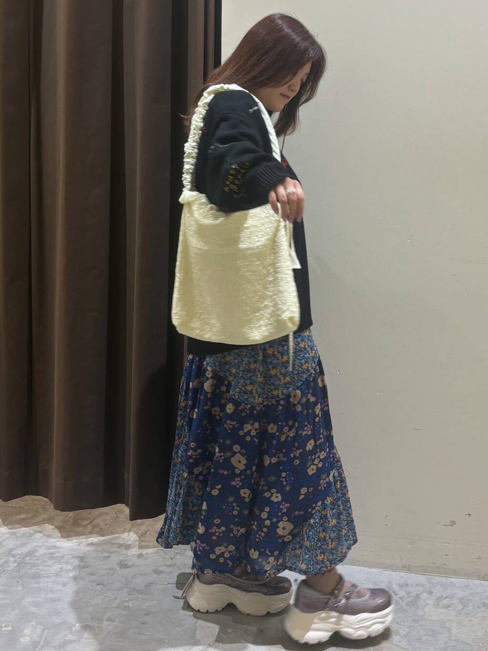 シルバー系のスニーカー、ブルー系のスカート、ホワイト系のシャツ/ブラウスを着用したレディースの秋コーディネートの5枚目の写真