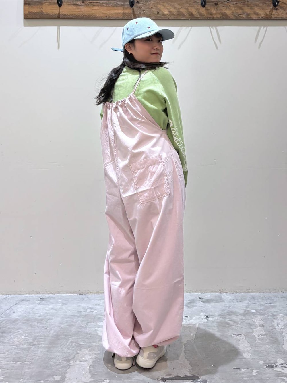 ピンク系のサロペット/オーバーオール、グレー系のスニーカー、グリーン系のスウェットを着用したレディースの春コーディネートの6枚目の写真