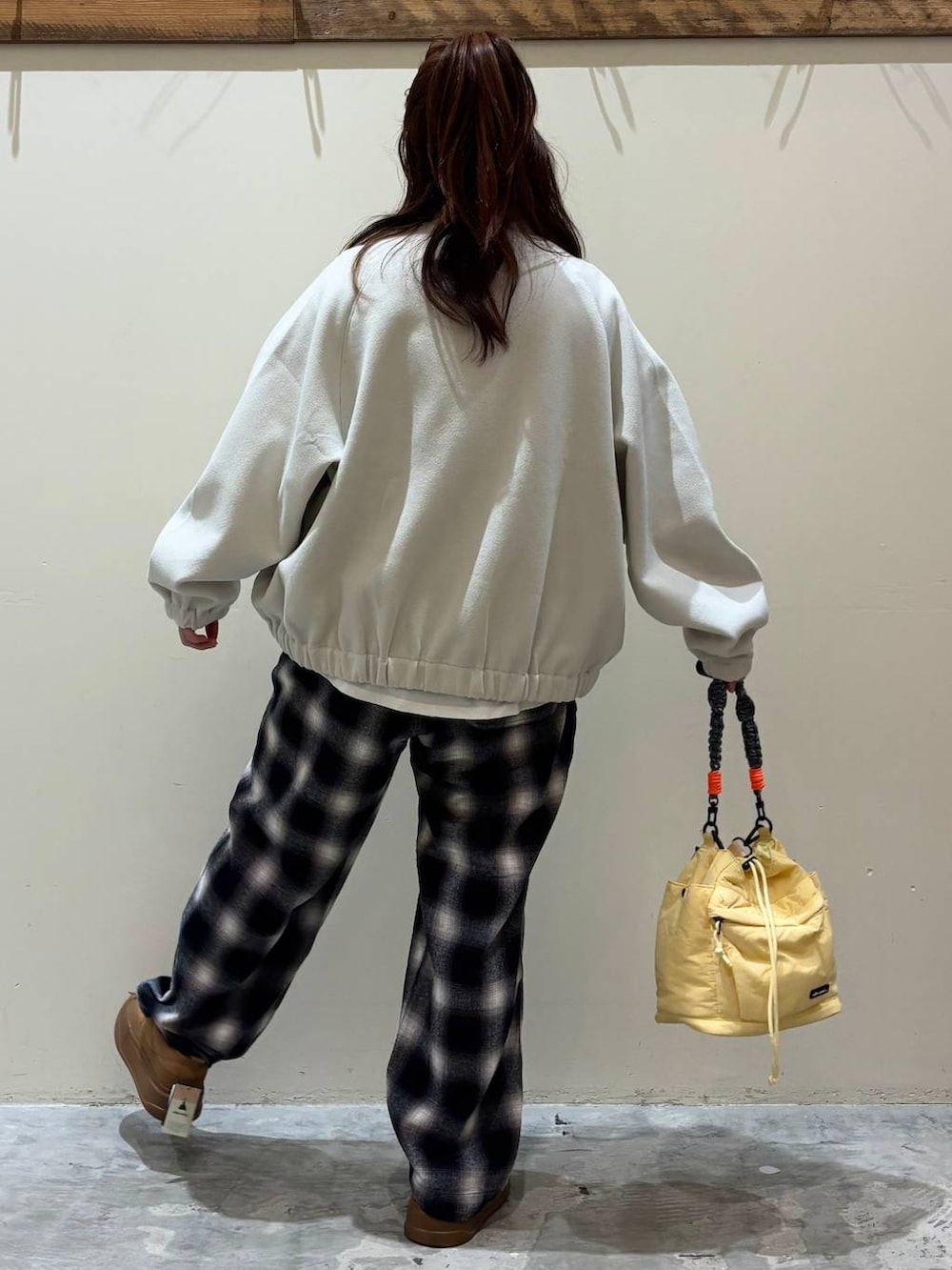 ブラウン系のスニーカー、イエロー系のショルダーバッグを着用したレディースの冬コーディネートの9枚目の写真