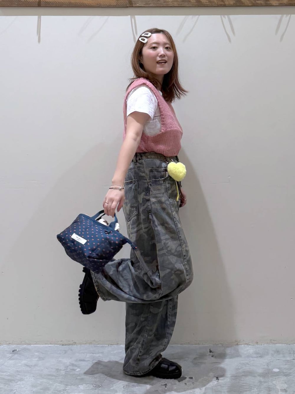 ピンク系のベスト、その他のトートバッグ、グリーン系のデニムパンツを着用したレディースの夏コーディネートの5枚目の写真