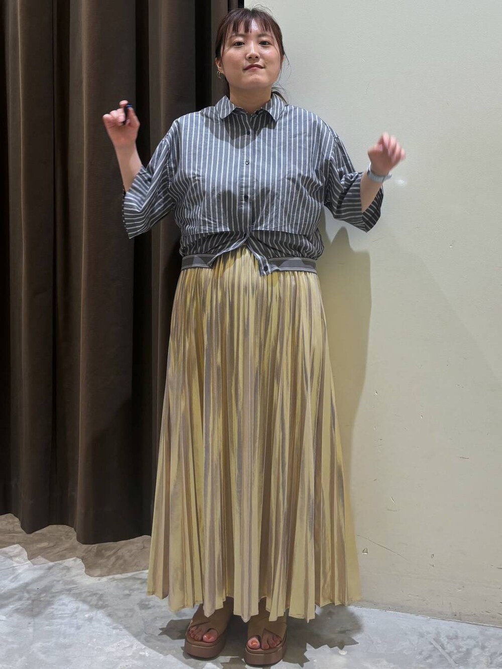 イエロー系のサンダル、イエロー系のスカート、グレー系のシャツ/ブラウスを着用したレディースの夏コーディネートの6枚目の写真