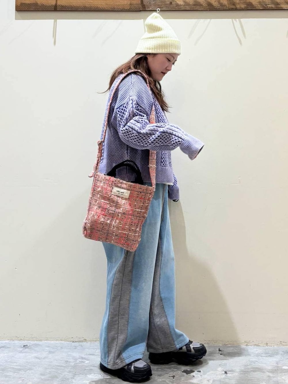 グレー系のデニムパンツ、グレー系のスニーカー、ピンク系のトートバッグを着用したレディースの冬コーディネートの5枚目の写真