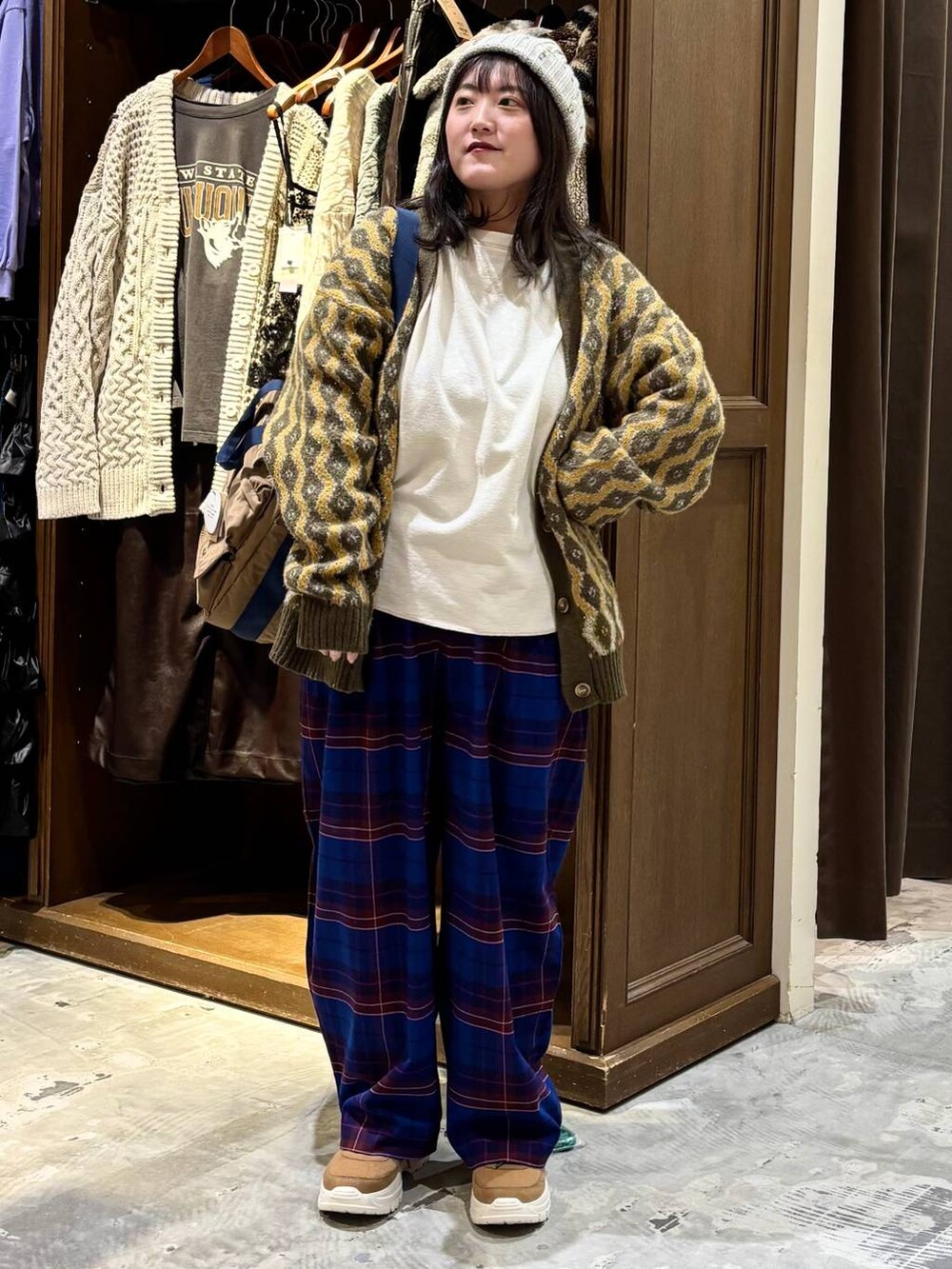 ブルー系のその他パンツ、ベージュ系のTシャツ/カットソー、ブラウン系のトートバッグを着用したレディースの冬コーディネートの3枚目の写真