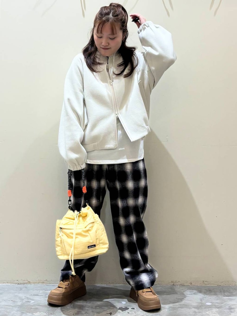 ブラウン系のスニーカー、イエロー系のショルダーバッグを着用したレディースの冬コーディネートの2枚目の写真