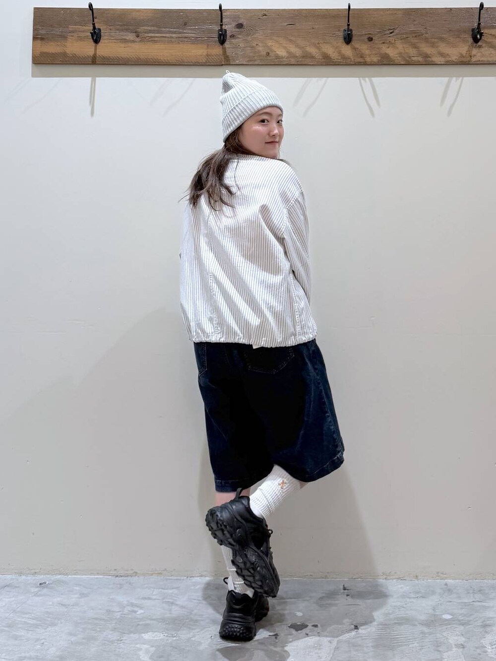 ブラック系のスニーカー、ベージュ系のカバーオール、レッド系のTシャツ/カットソーを着用したレディースの春コーディネートの4枚目の写真