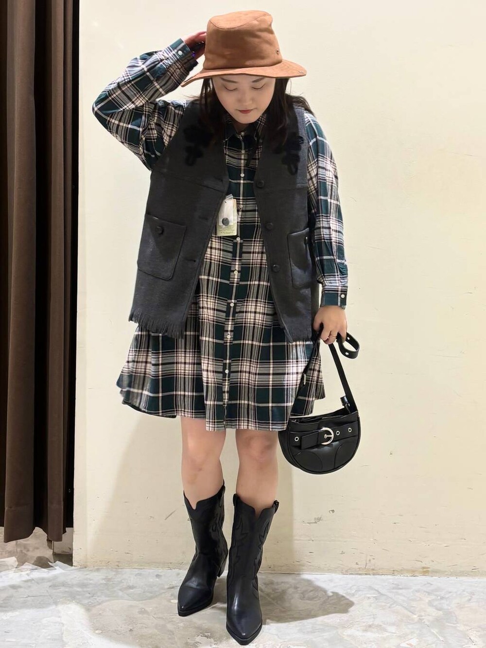 グリーン系のシャツ/ブラウス、ブラック系のブーツ、グレー系のベストを着用したレディースの秋コーディネートの4枚目の写真