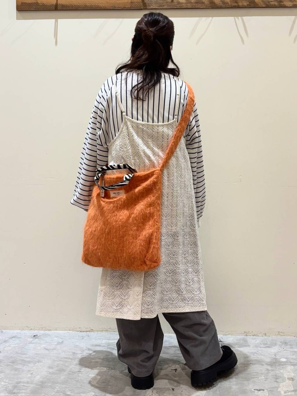 グレー系のその他パンツ、オレンジ系のトートバッグ、ブラック系のその他シューズを着用したレディースの秋コーディネートの4枚目の写真