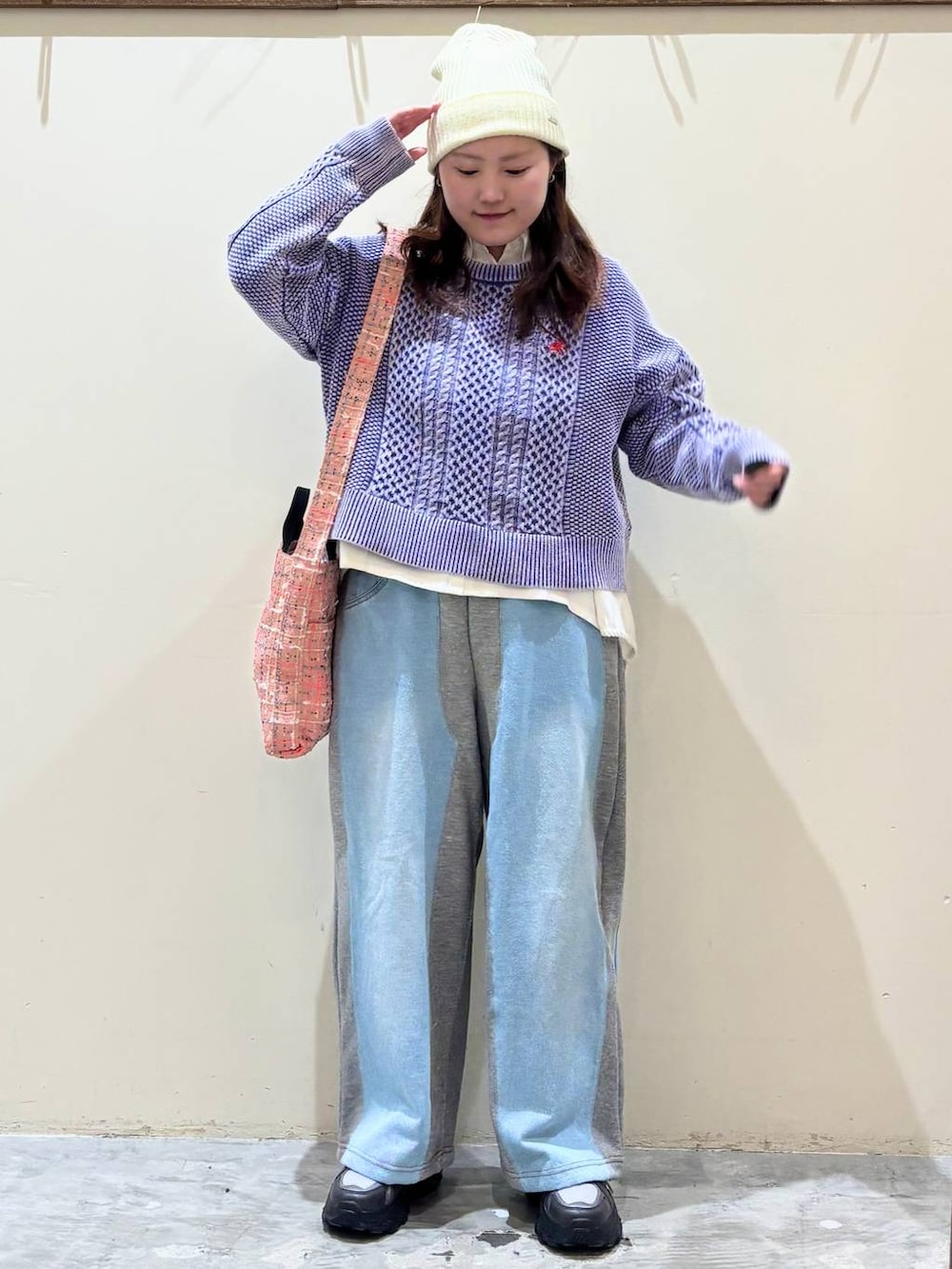 グレー系のデニムパンツ、グレー系のスニーカー、ピンク系のトートバッグを着用したレディースの冬コーディネートの2枚目の写真