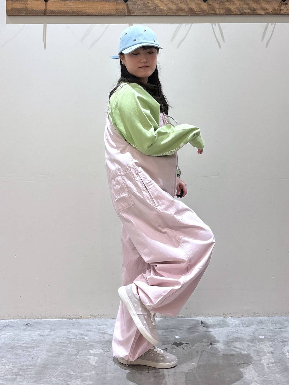 ピンク系のサロペット/オーバーオール、グレー系のスニーカー、グリーン系のスウェットを着用したレディースの春コーディネートの5枚目の写真