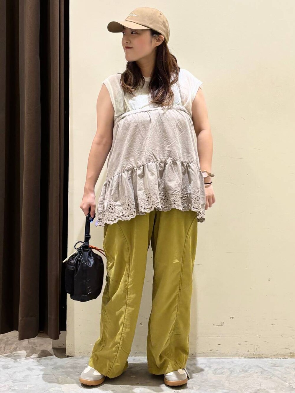 イエロー系のその他パンツ、ホワイト系のタンクトップ、ベージュ系のスニーカーを着用したレディースの夏コーディネートの3枚目の写真