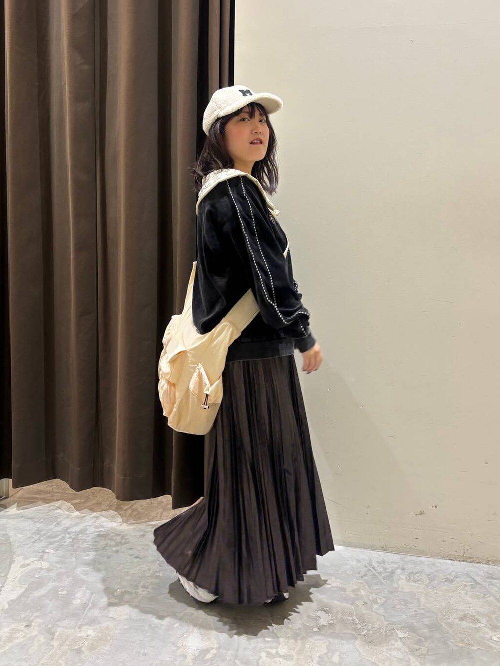 ホワイト系のスニーカー、グレー系のTシャツ/カットソー、ベージュ系のショルダーバッグを着用したレディースの秋コーディネートの5枚目の写真