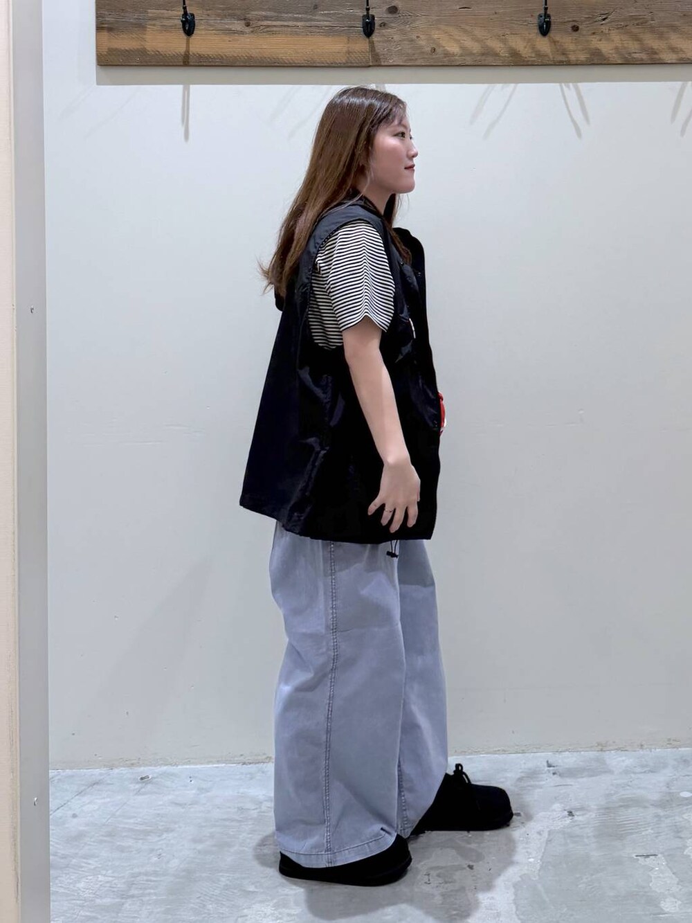 ブルー系のその他パンツ、ブラック系のスニーカー、ブラック系のベストを着用したレディースの春コーディネートの3枚目の写真