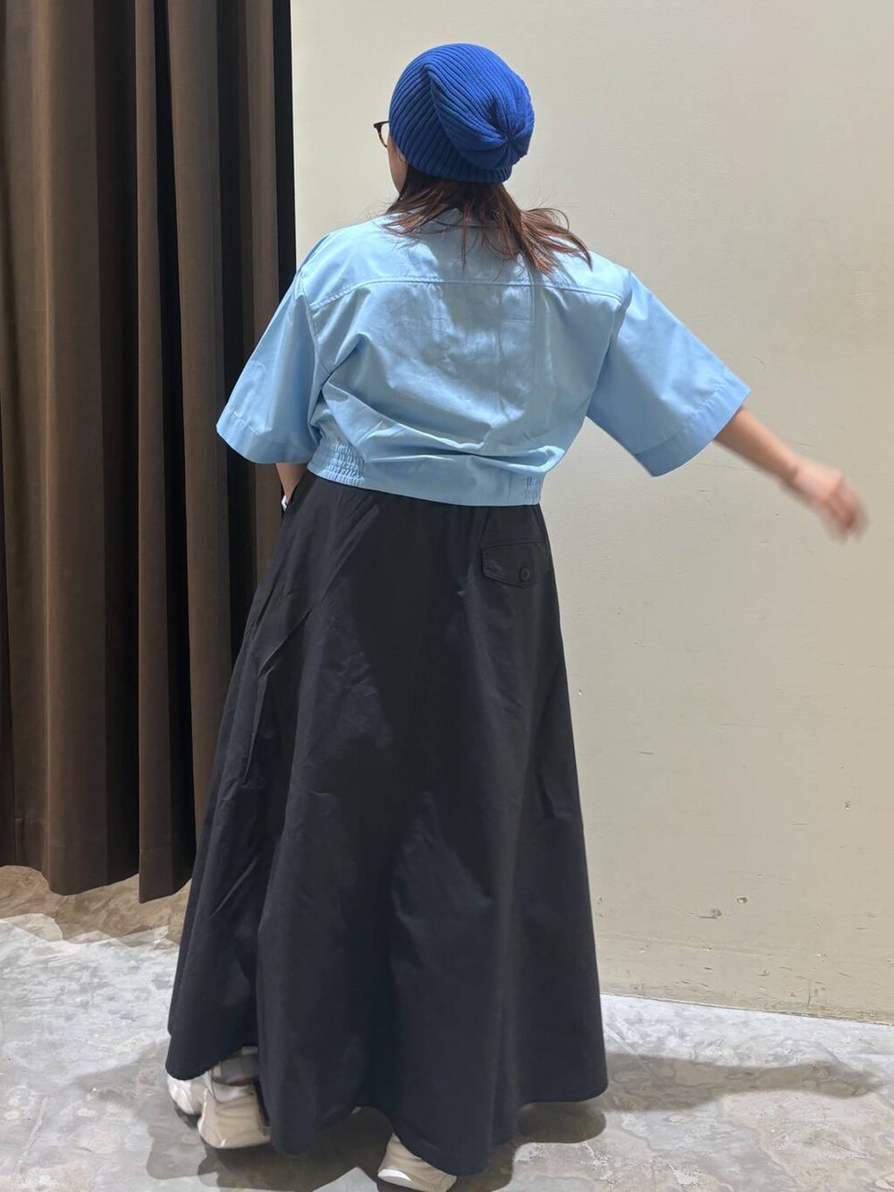 シルバー系のトートバッグ、シルバー系のスニーカー、グレー系のスカートを着用したレディースの夏コーディネートの6枚目の写真