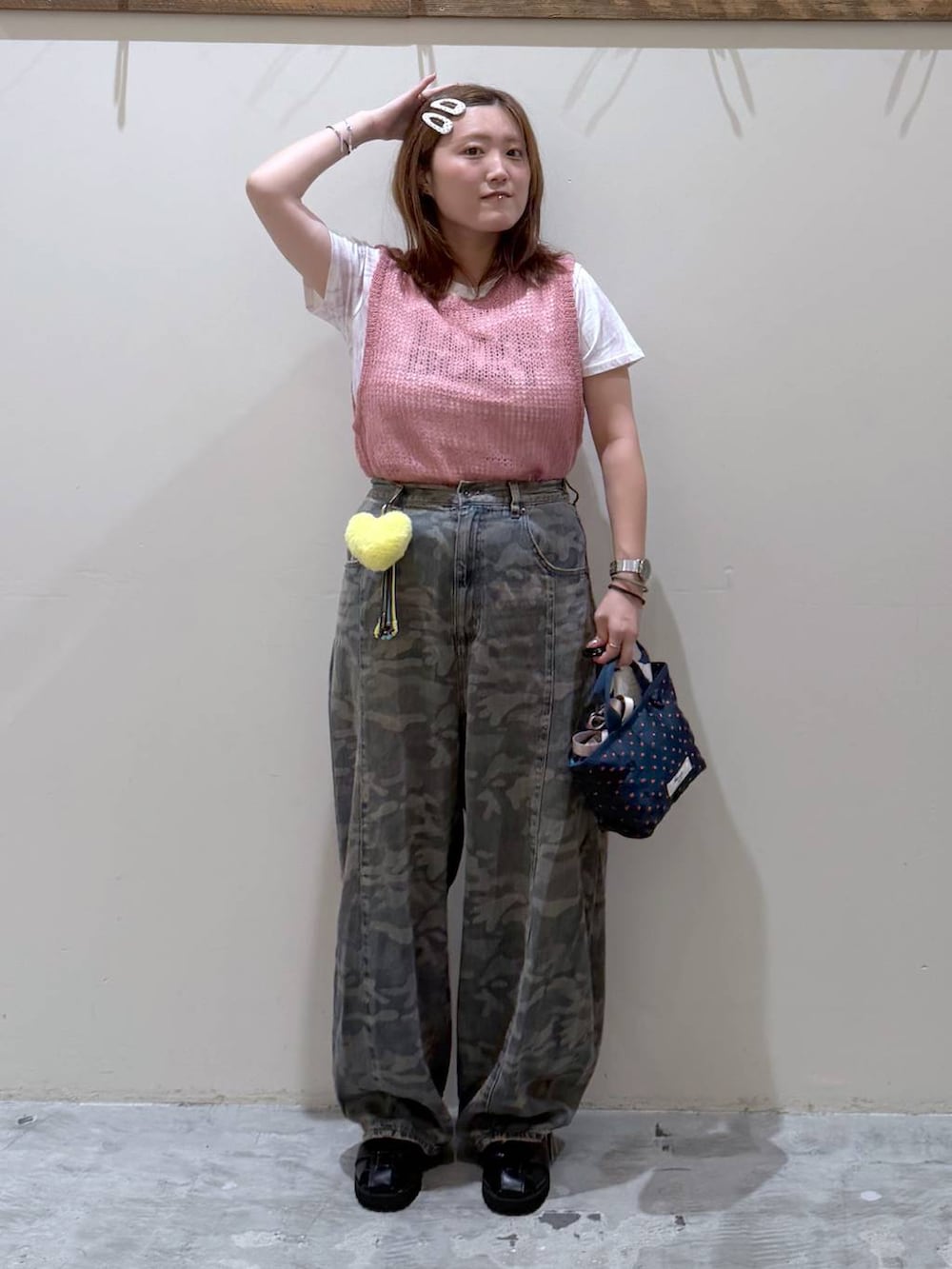 ピンク系のベスト、その他のトートバッグ、グリーン系のデニムパンツを着用したレディースの夏コーディネートの3枚目の写真
