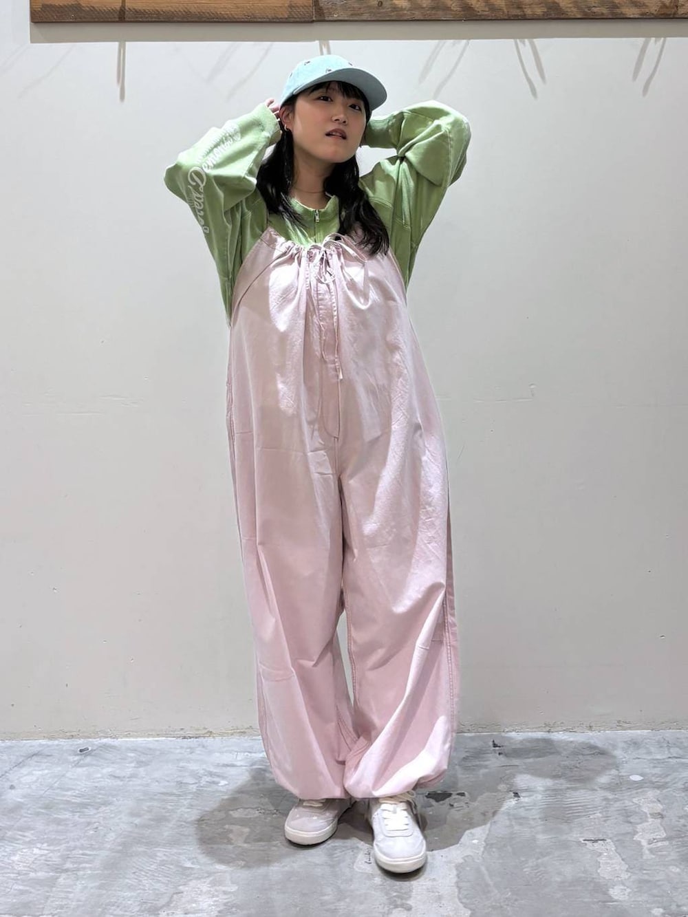 ピンク系のサロペット/オーバーオール、グレー系のスニーカー、グリーン系のスウェットを着用したレディースの春コーディネートの2枚目の写真