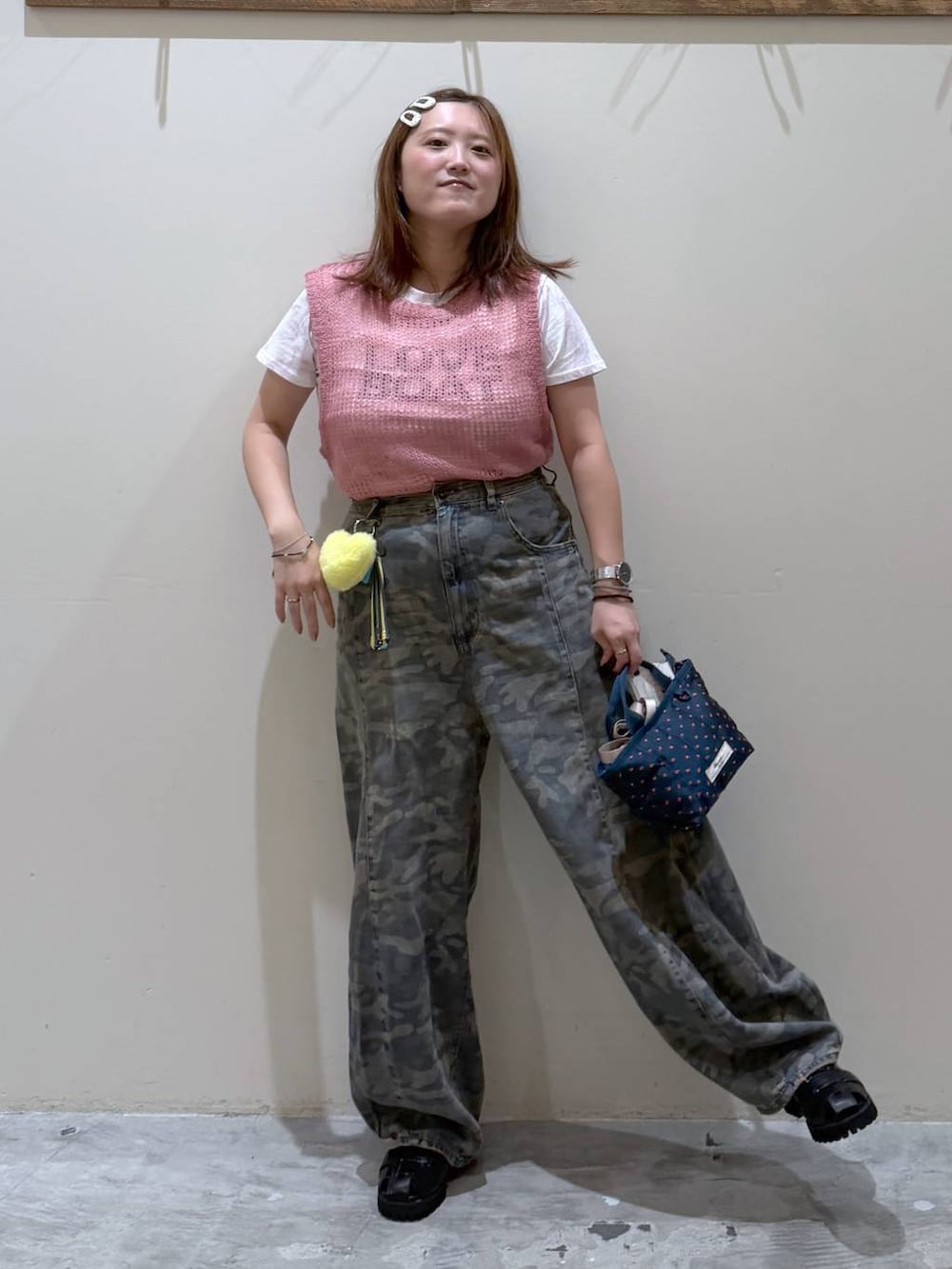 ピンク系のベスト、その他のトートバッグ、グリーン系のデニムパンツを着用したレディースの夏コーディネートの2枚目の写真