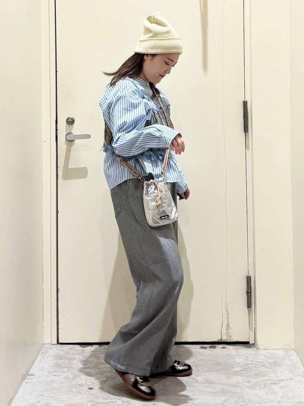 シルバー系のショルダーバッグ、グレー系のその他パンツ、シルバー系のスニーカーを着用したレディースの春コーディネートの5枚目の写真