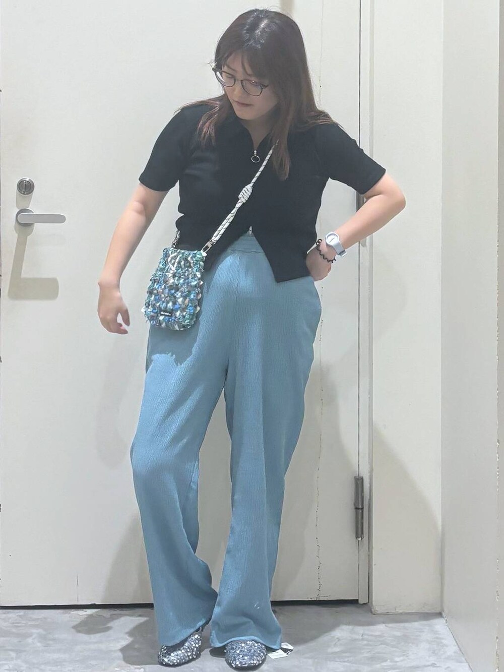 ブルー系のその他パンツ、シルバー系のバレエシューズ、グリーン系のショルダーバッグを着用したレディースの夏コーディネートの3枚目の写真