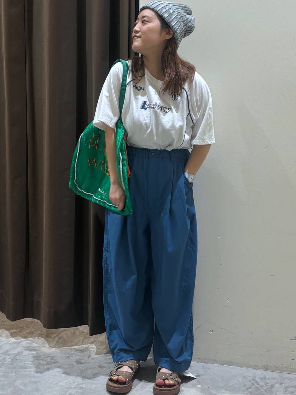 ベージュ系のサンダル、ブルー系のその他パンツ、グリーン系のトートバッグを着用したレディースの夏コーディネートの2枚目の写真