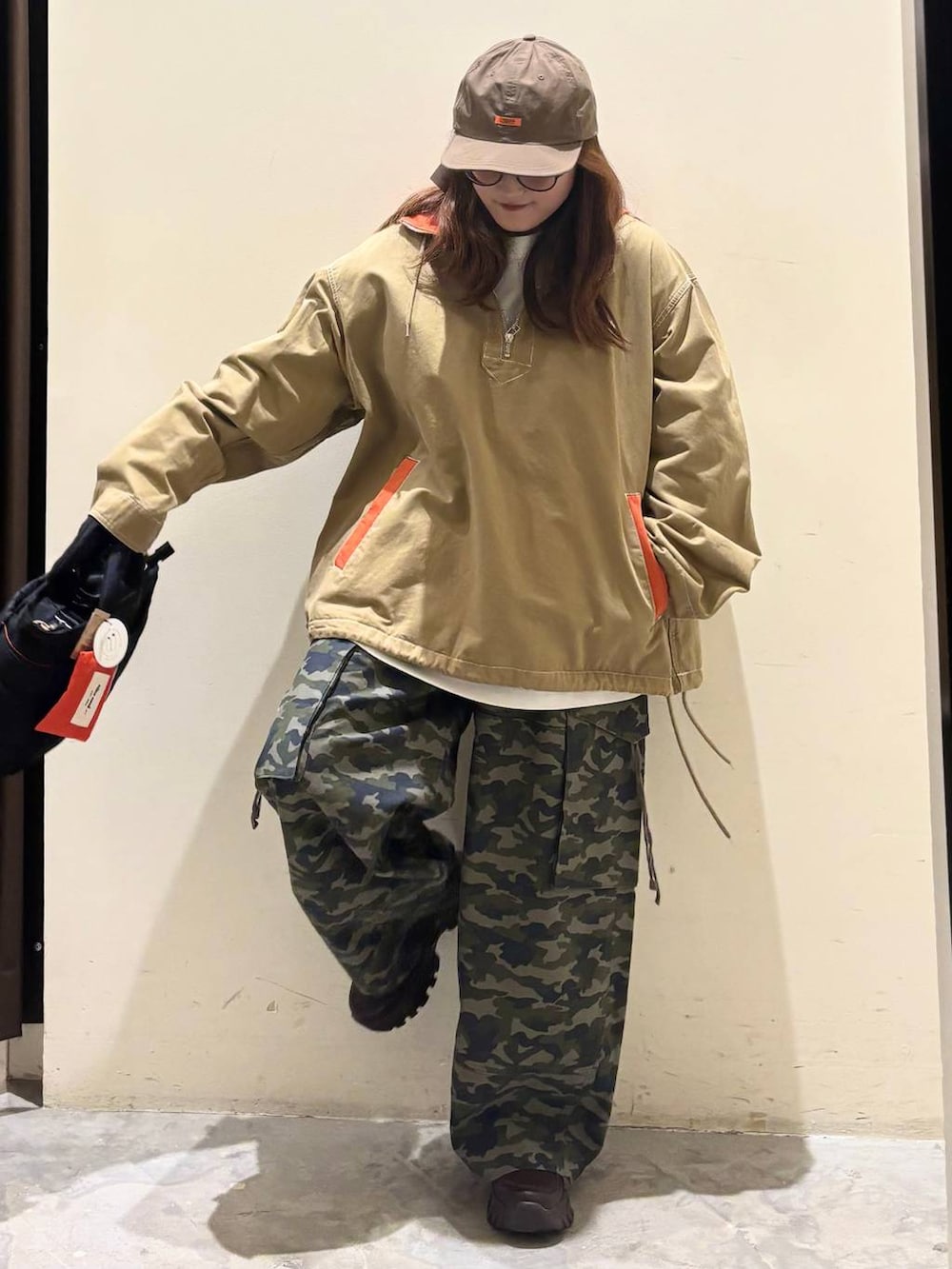 ブラック系のトートバッグ、ブラウン系のスニーカー、ベージュ系のパーカーを着用したレディースの春コーディネートの4枚目の写真