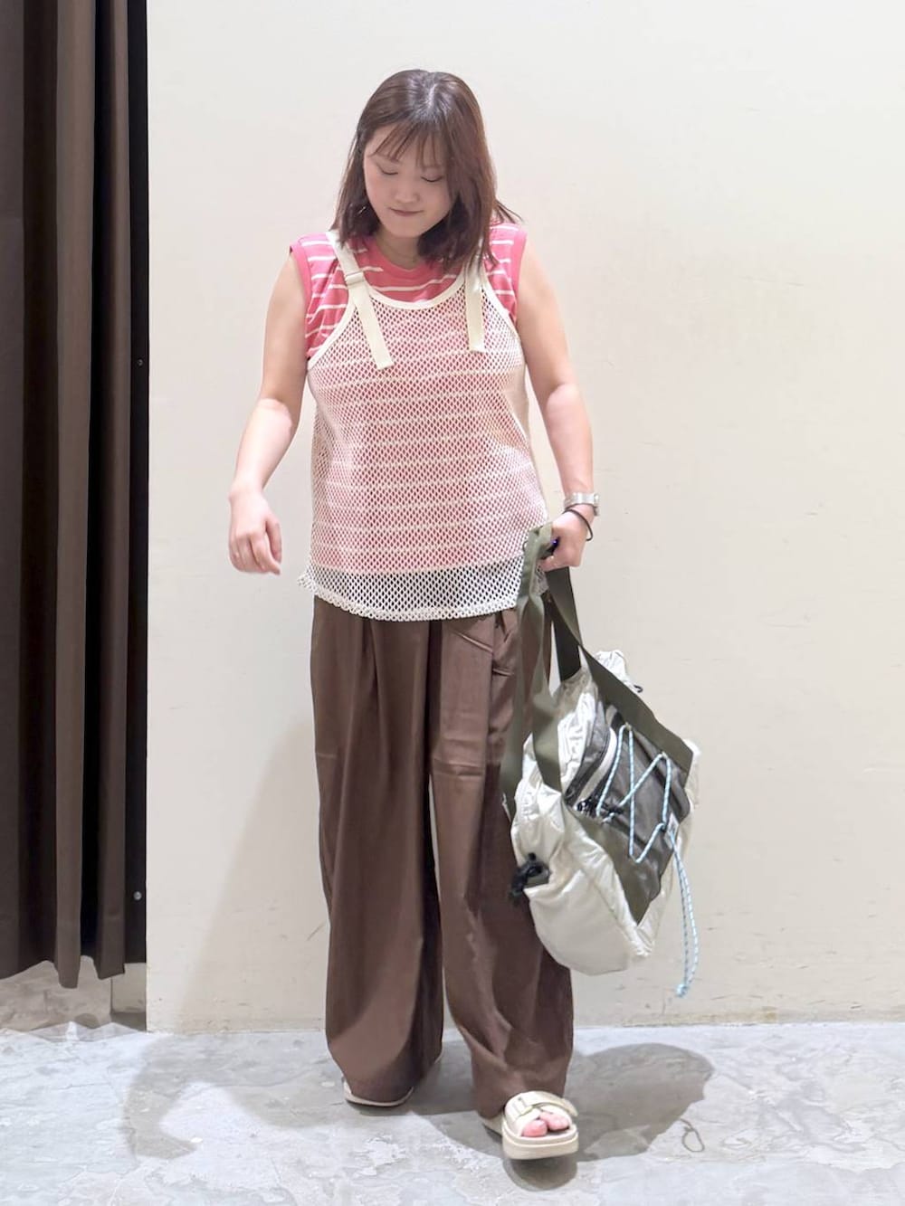 ベージュ系のサンダル、ベージュ系のボストンバッグ、ピンク系のTシャツ/カットソーを着用したレディースの夏コーディネートの2枚目の写真