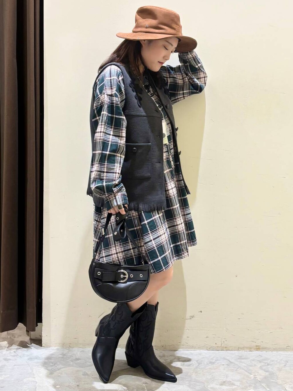 グリーン系のシャツ/ブラウス、ブラック系のブーツ、グレー系のベストを着用したレディースの秋コーディネートの5枚目の写真