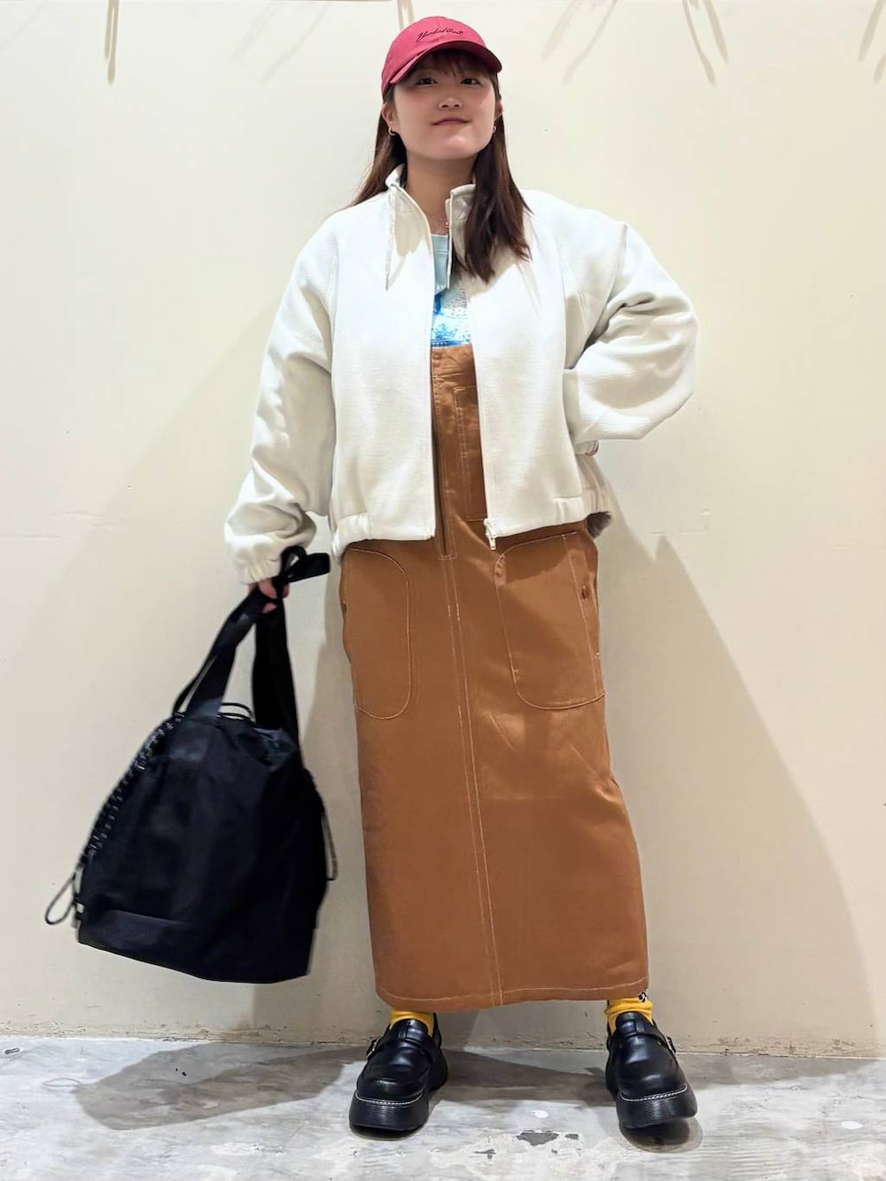 ブラック系のドレスシューズ、ブラウン系のジャンパースカート、ベージュ系のブルゾンを着用したレディースの冬コーディネートの5枚目の写真