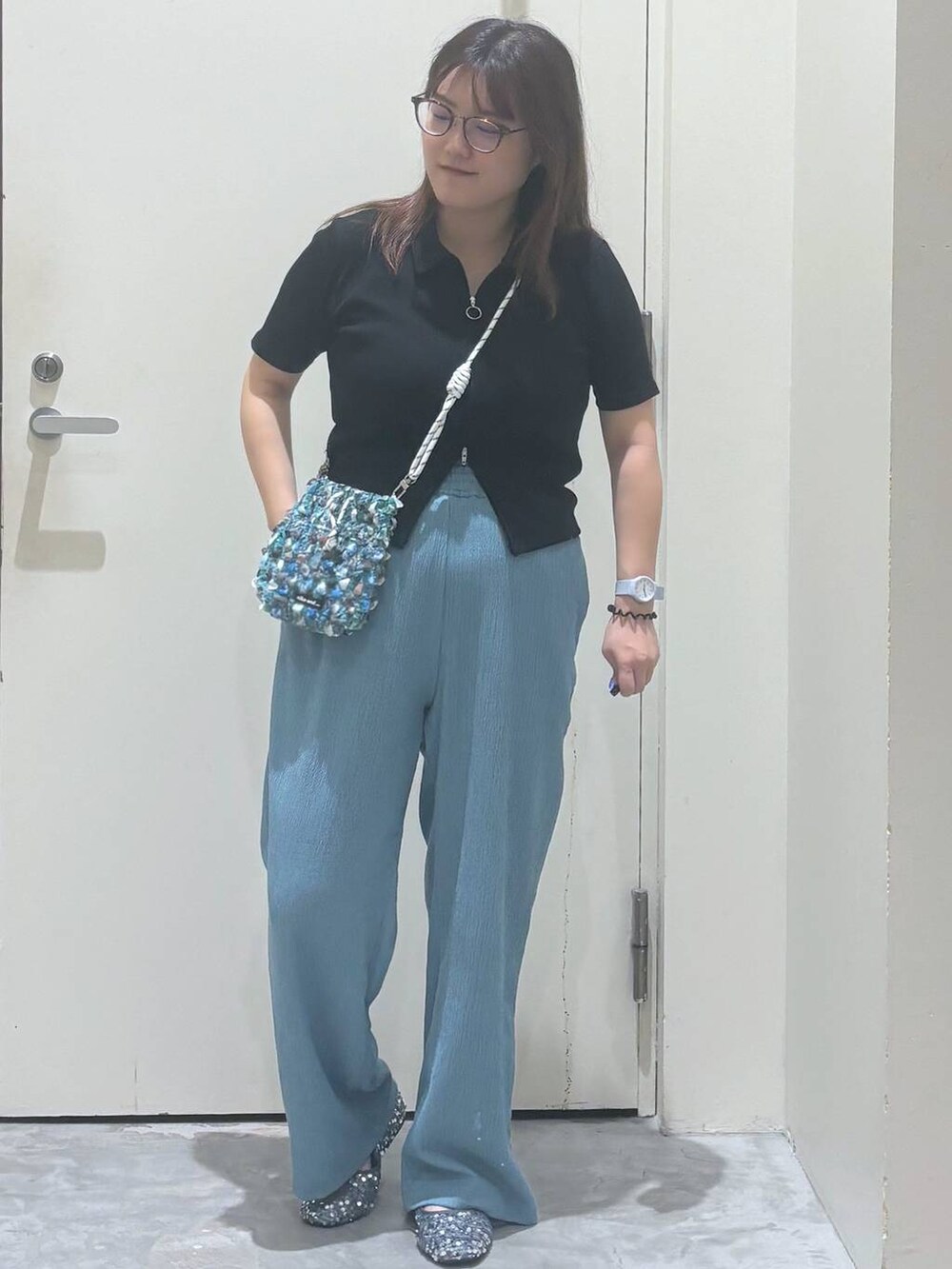 ブルー系のその他パンツ、シルバー系のバレエシューズ、グリーン系のショルダーバッグを着用したレディースの夏コーディネートの2枚目の写真