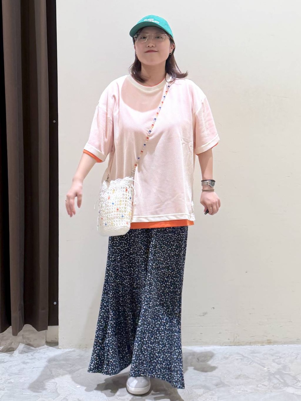 ブルー系のスカート、グレー系のスニーカー、その他のTシャツ/カットソーを着用したレディースの夏コーディネートの2枚目の写真