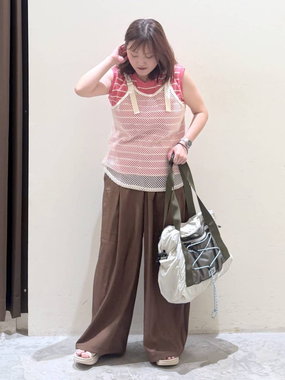 ベージュ系のサンダル、ベージュ系のボストンバッグ、ピンク系のTシャツ/カットソーを着用したレディースの夏コーディネートの5枚目の写真