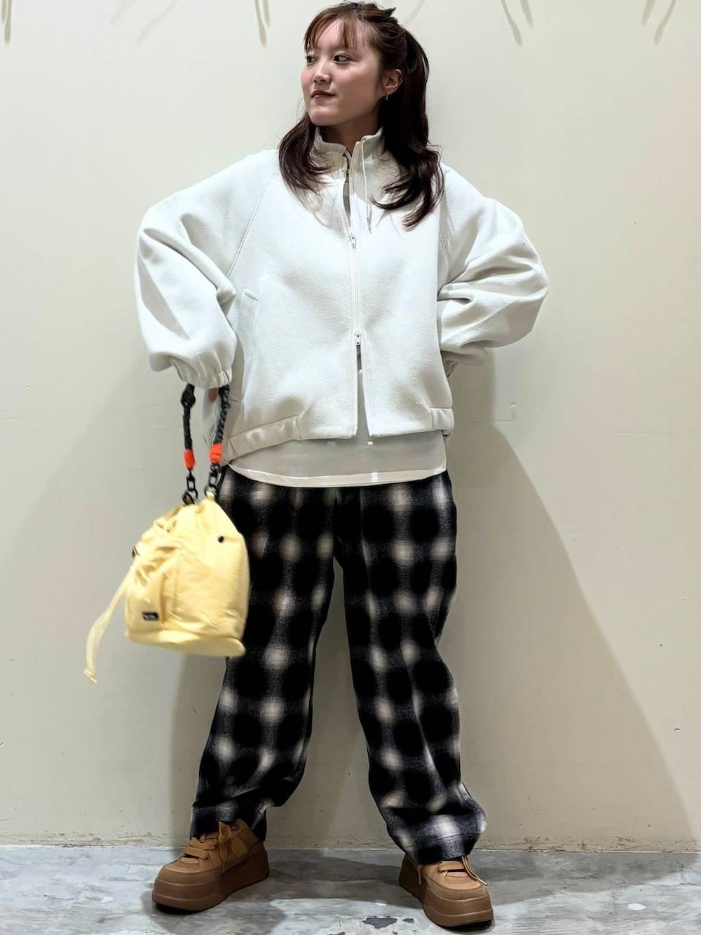 ブラウン系のスニーカー、イエロー系のショルダーバッグを着用したレディースの冬コーディネートの6枚目の写真