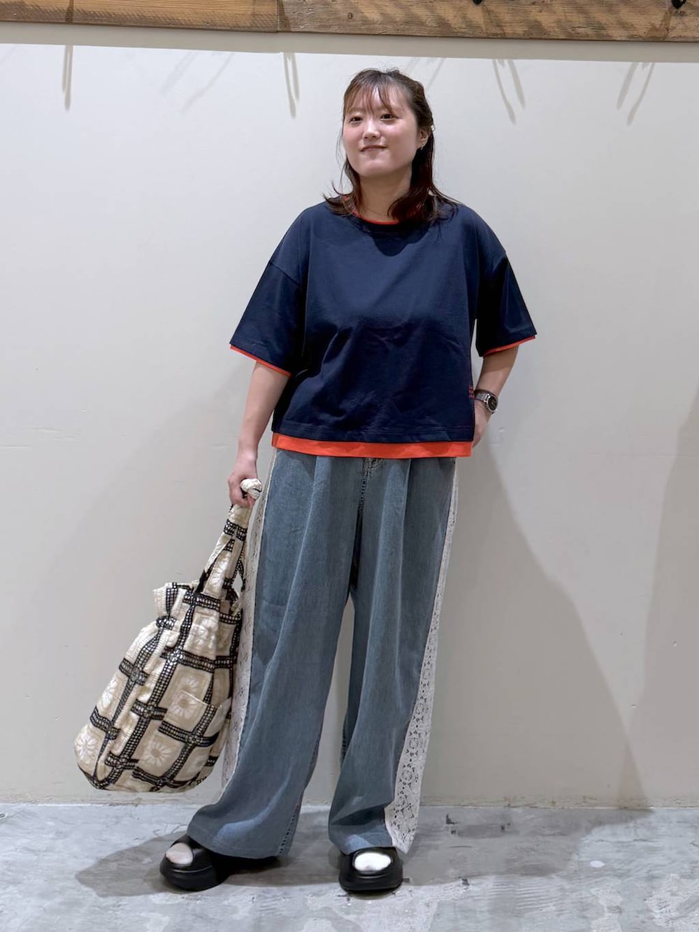 その他のトートバッグ、ブラック系のサンダル、ブルー系のTシャツ/カットソーを着用したレディースの夏コーディネートの4枚目の写真