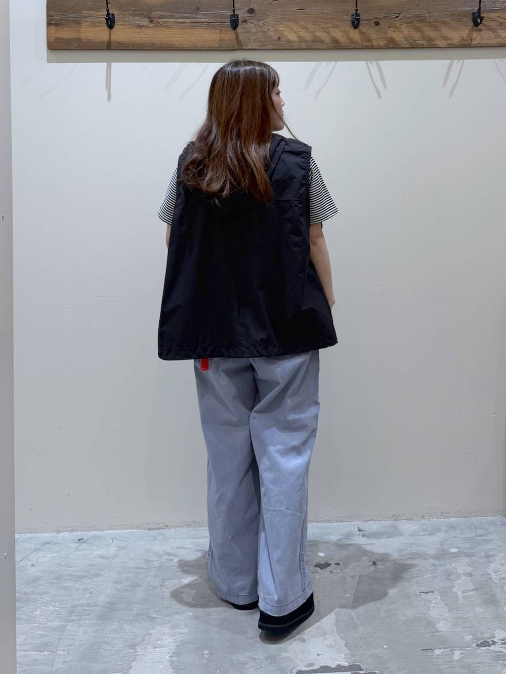 ブルー系のその他パンツ、ブラック系のスニーカー、ブラック系のベストを着用したレディースの春コーディネートの4枚目の写真
