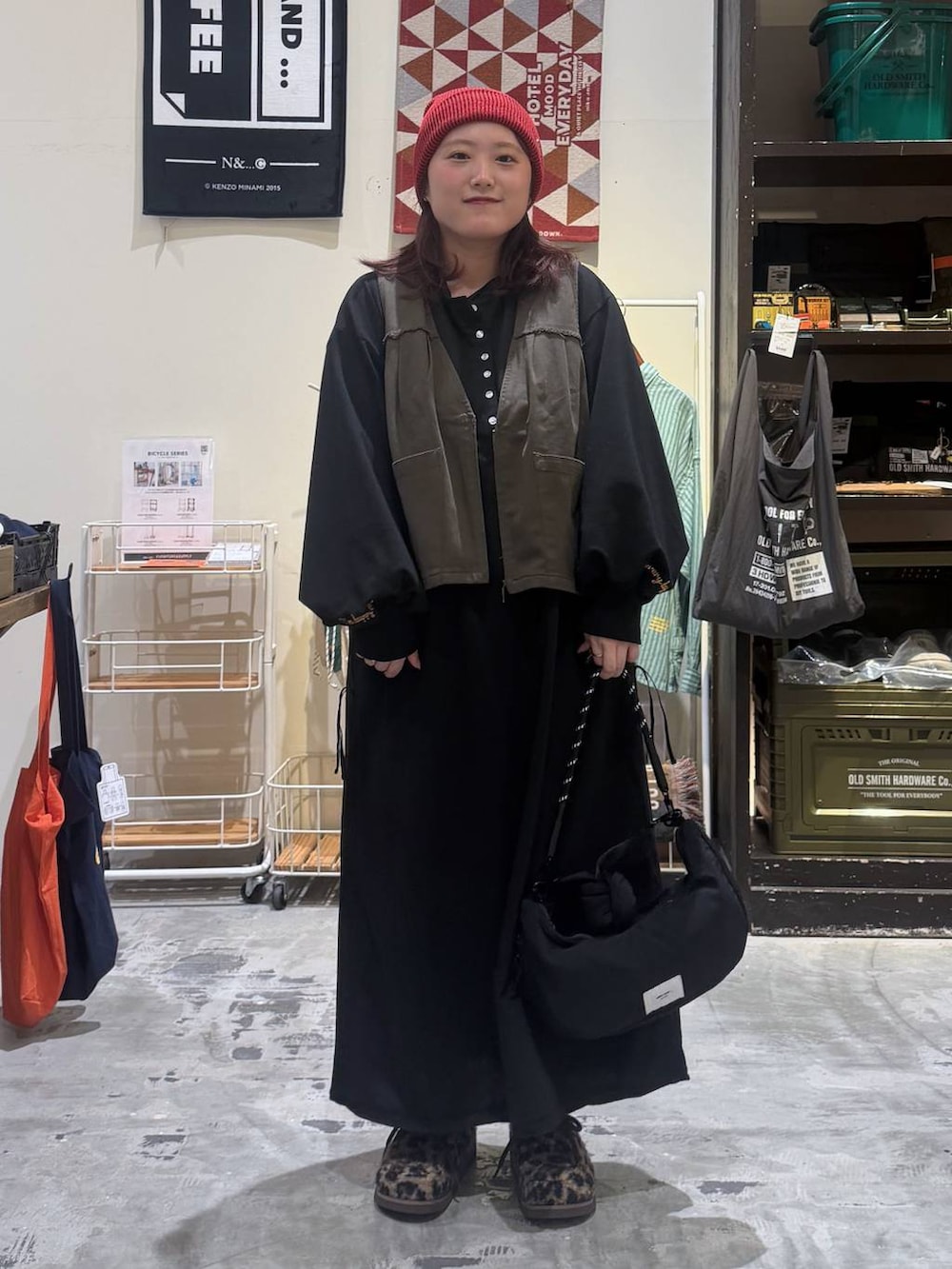 ブラック系のショルダーバッグ、その他のモカシン/デッキシューズ、レッド系のニットキャップ/ビーニーを着用したレディースの秋コーディネートの2枚目の写真