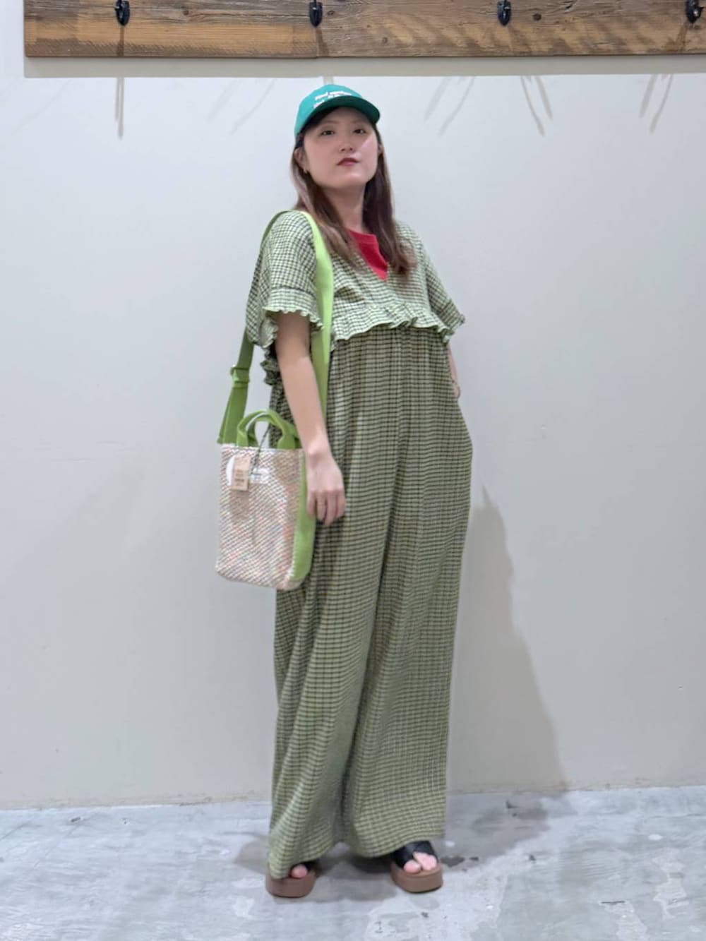 ブラック系のサンダル、レッド系のTシャツ/カットソー、イエロー系のつなぎ/オールインワンを着用したレディースの春コーディネートの2枚目の写真