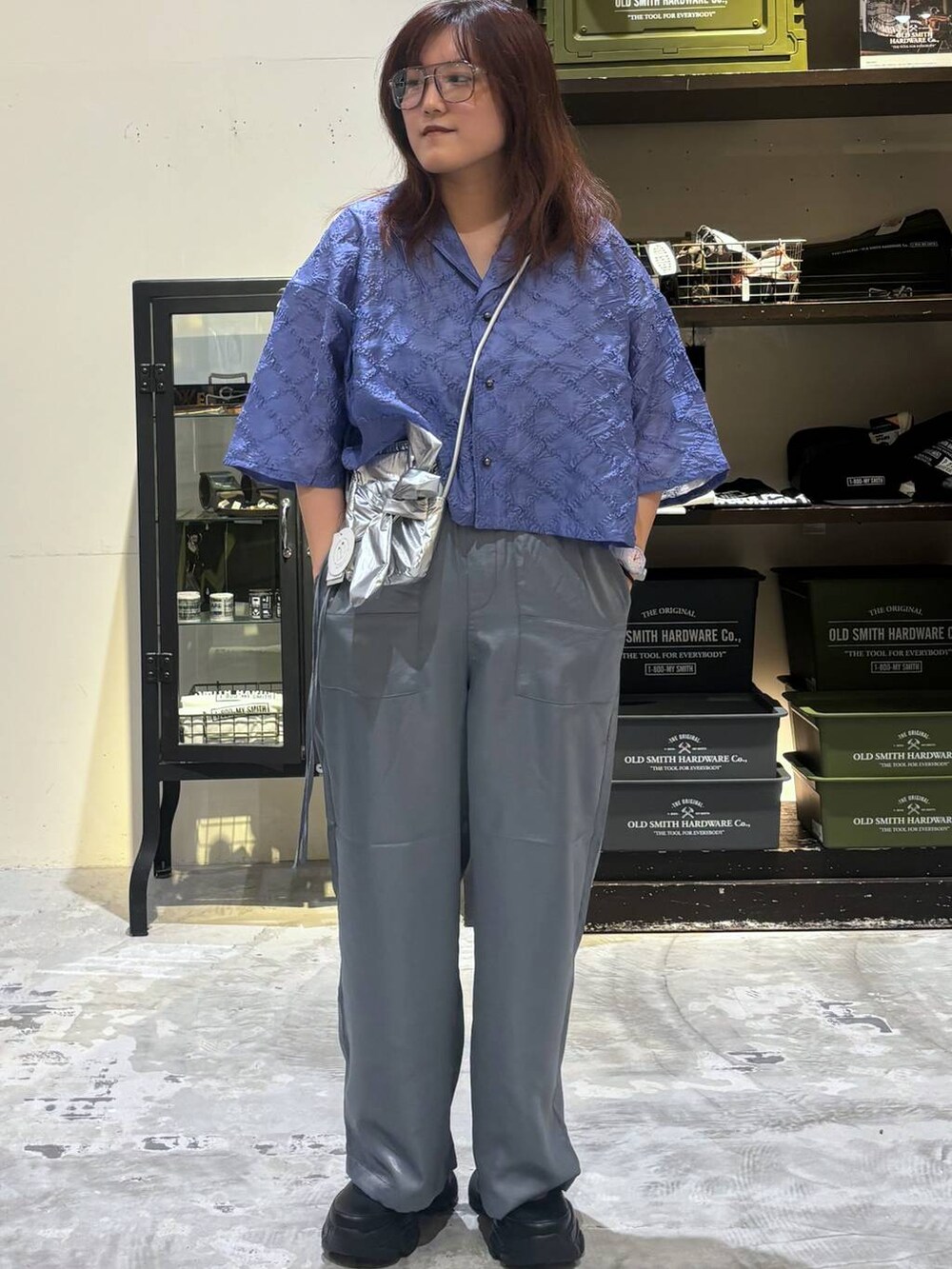 ブラック系のスニーカー、グレー系のショルダーバッグ、ブルー系のシャツ/ブラウスを着用したレディースの夏コーディネートの4枚目の写真