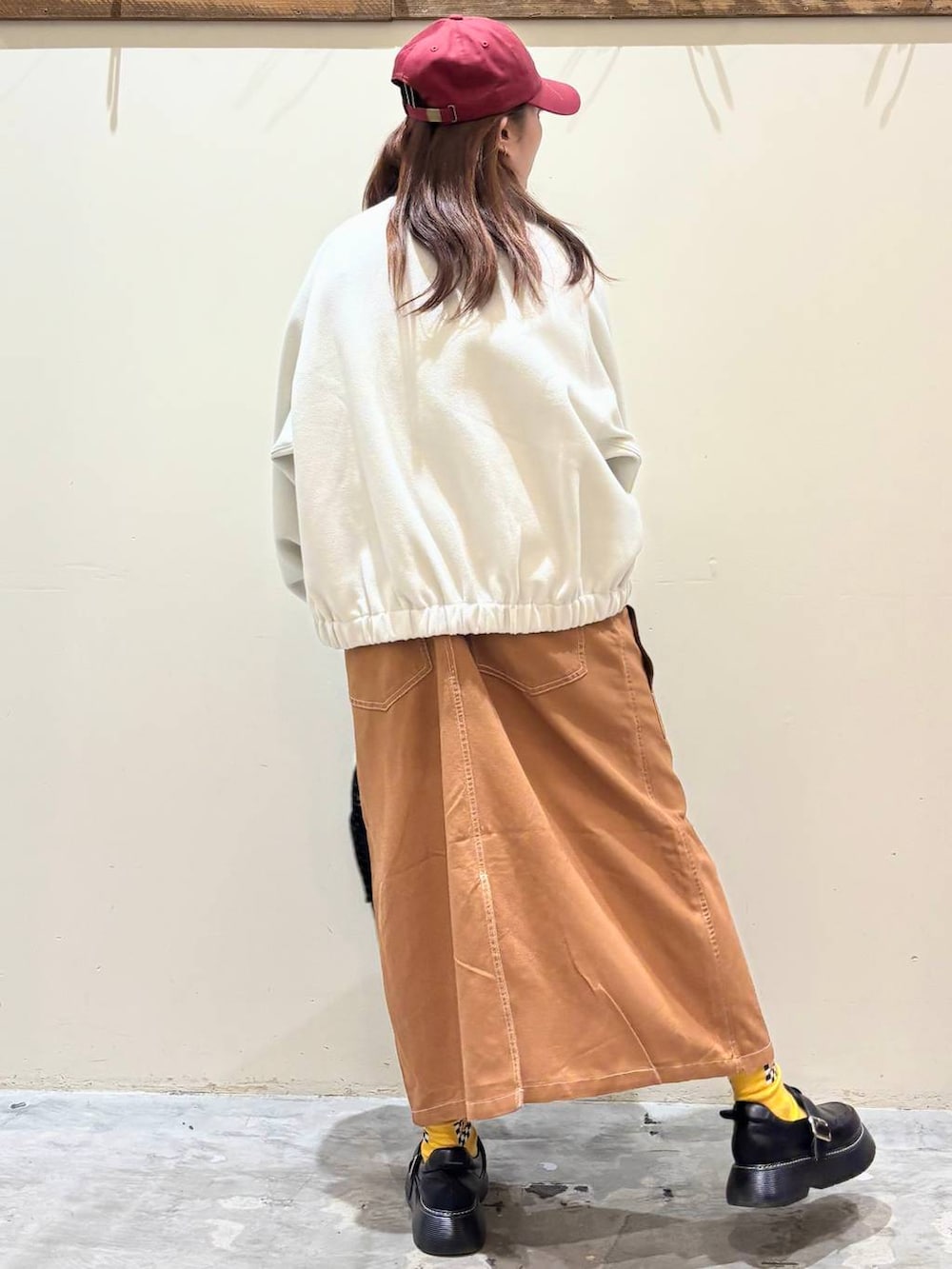 ブラック系のドレスシューズ、ブラウン系のジャンパースカート、ベージュ系のブルゾンを着用したレディースの冬コーディネートの7枚目の写真