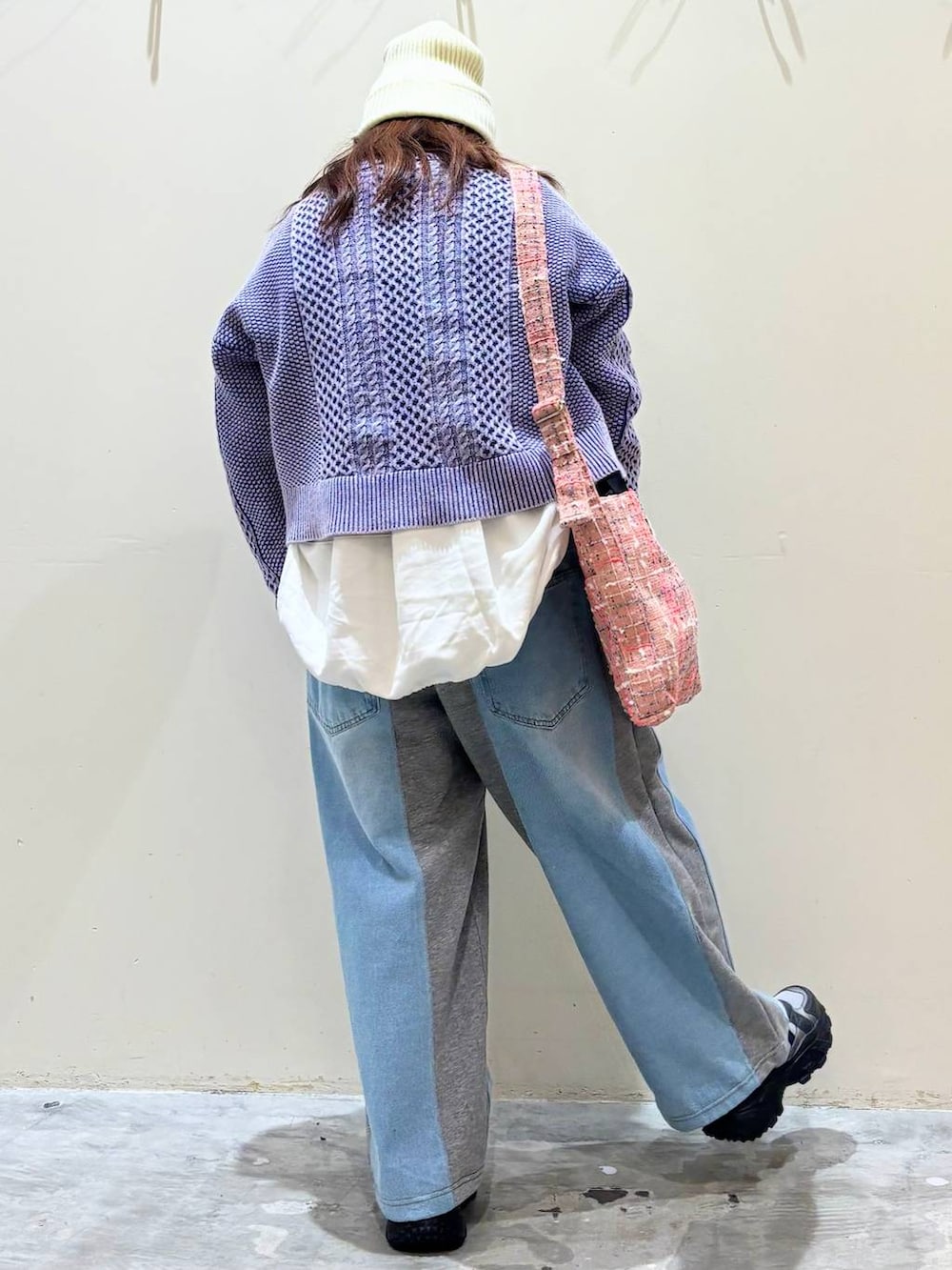 グレー系のデニムパンツ、グレー系のスニーカー、ピンク系のトートバッグを着用したレディースの冬コーディネートの6枚目の写真