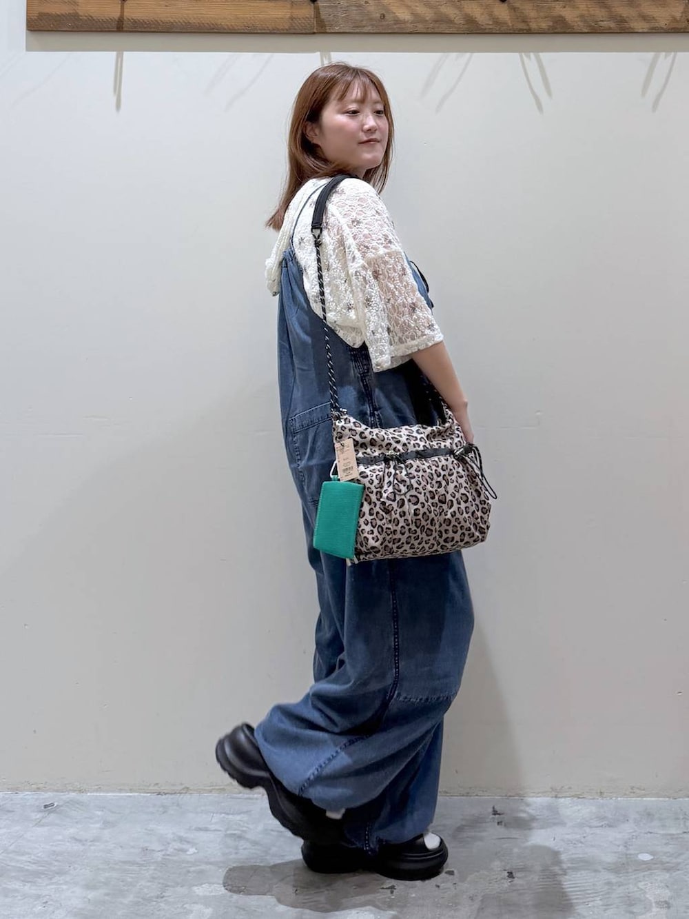 ベージュ系のTシャツ/カットソー、ブルー系のサロペット/オーバーオール、ブラック系のサンダルを着用したレディースの夏コーディネートの5枚目の写真