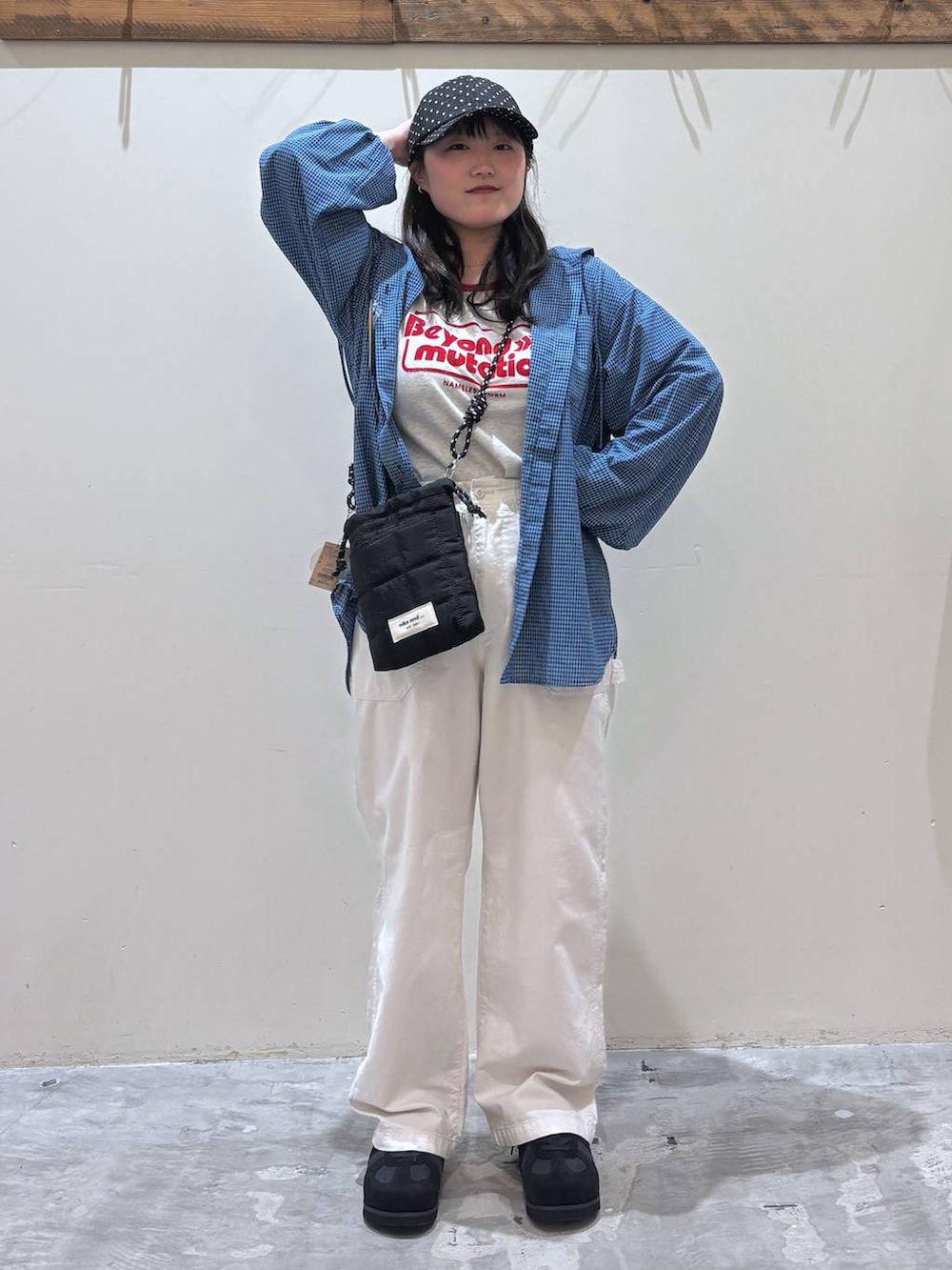 ブラック系のショルダーバッグ、ベージュ系のその他パンツ、ブルー系のシャツ/ブラウスを着用したレディースの春コーディネートの2枚目の写真